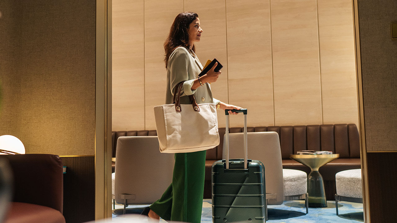 Woman with luggage in hotel.