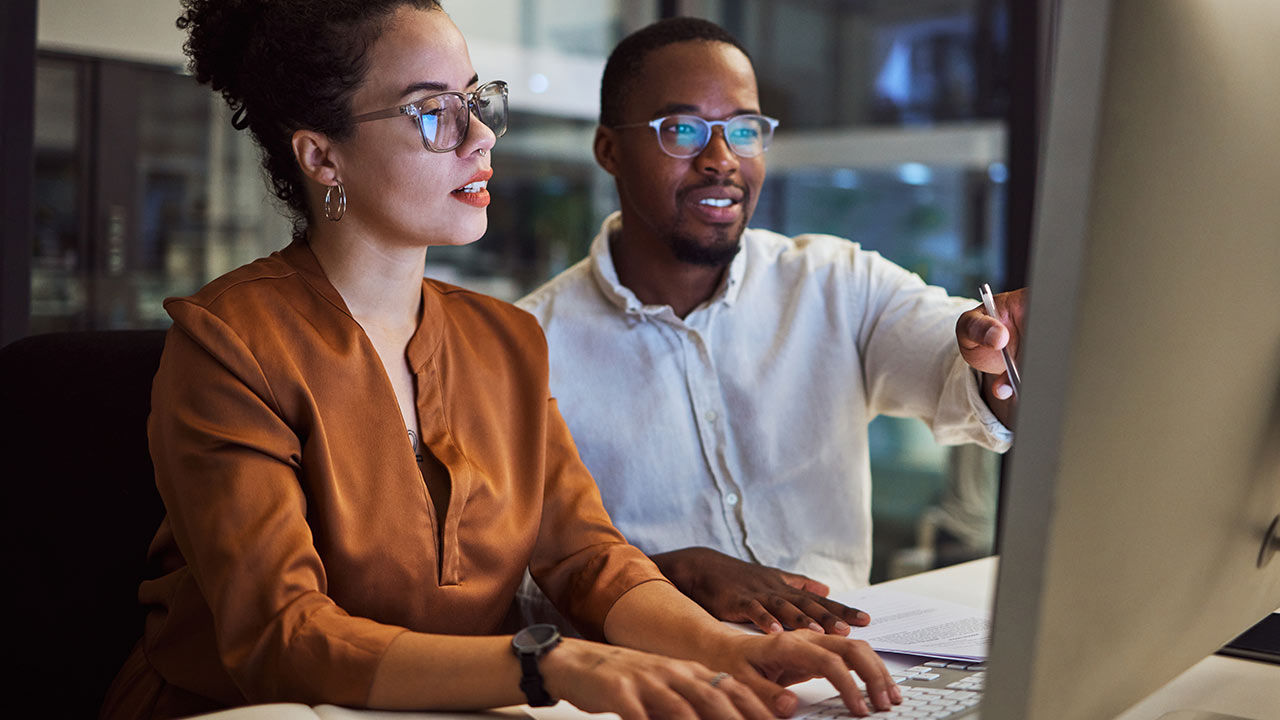 Des employés qui planifient une stratégie marketing dans un bureau sombre.