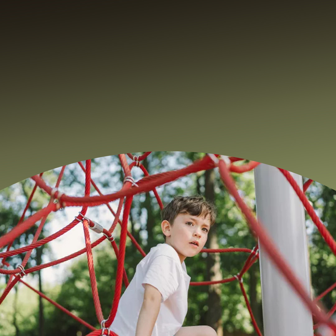Young boy playing on a playground.