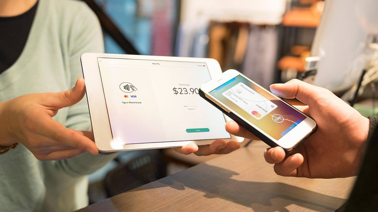 Customer making a purchase using tap on smartphone to pay on a tablet pos system.