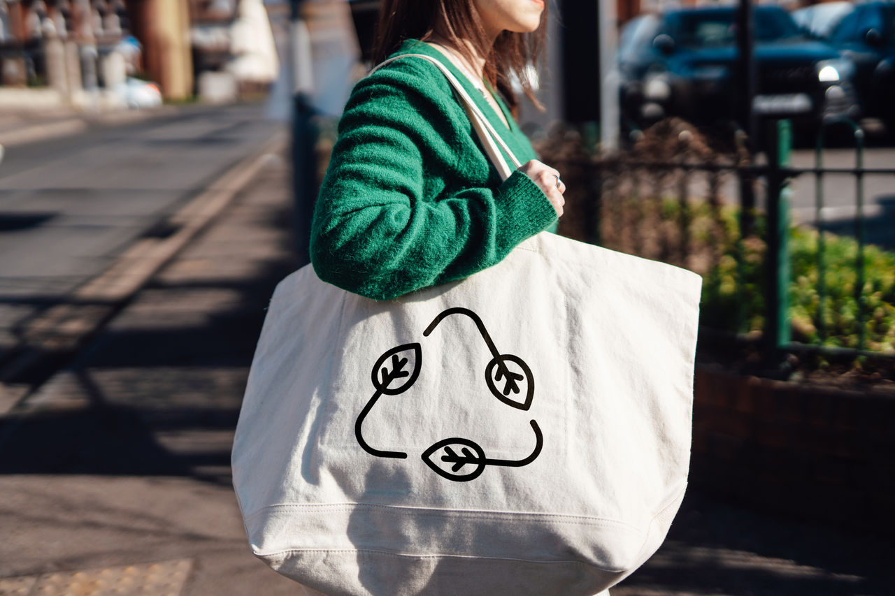 woman with large canvas bag with recyling symbol on it