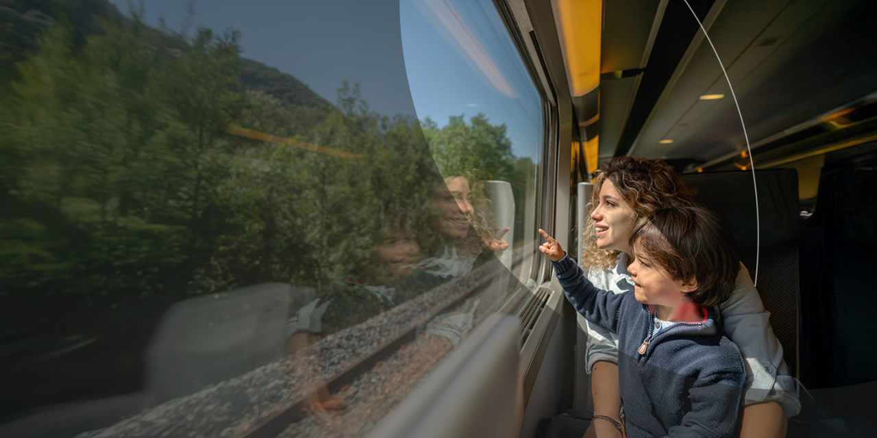 A woman and her child looking out of a train window.