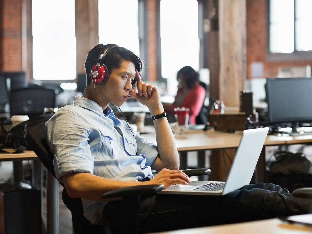 hombre en una computadora con auriculares puestos