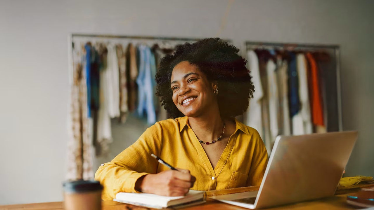 Mujer sonriente trabajando en una computadora portátil.