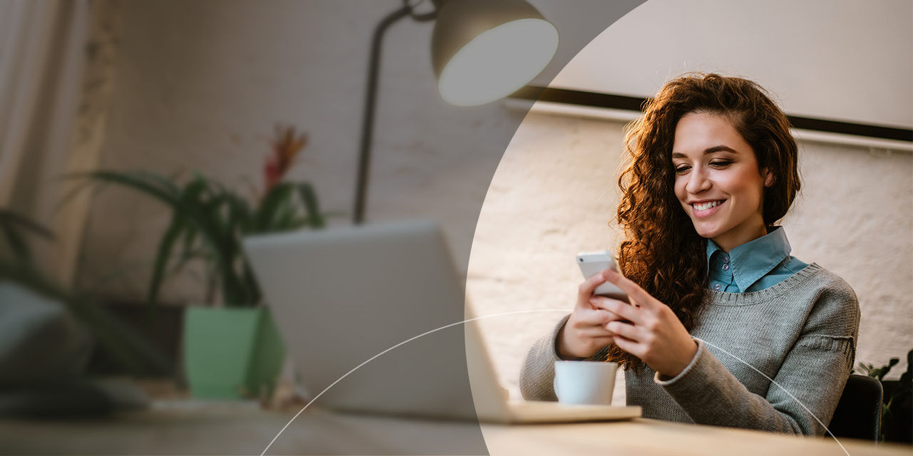 Girl looking into her phone over a coffee.