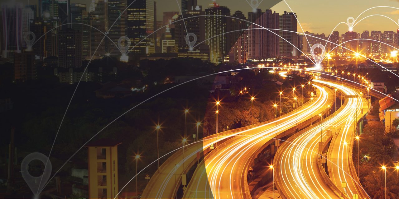 An aerial view of a modern smart city featuring eco-friendly architecture, smart transport systems, and digital connectivity.