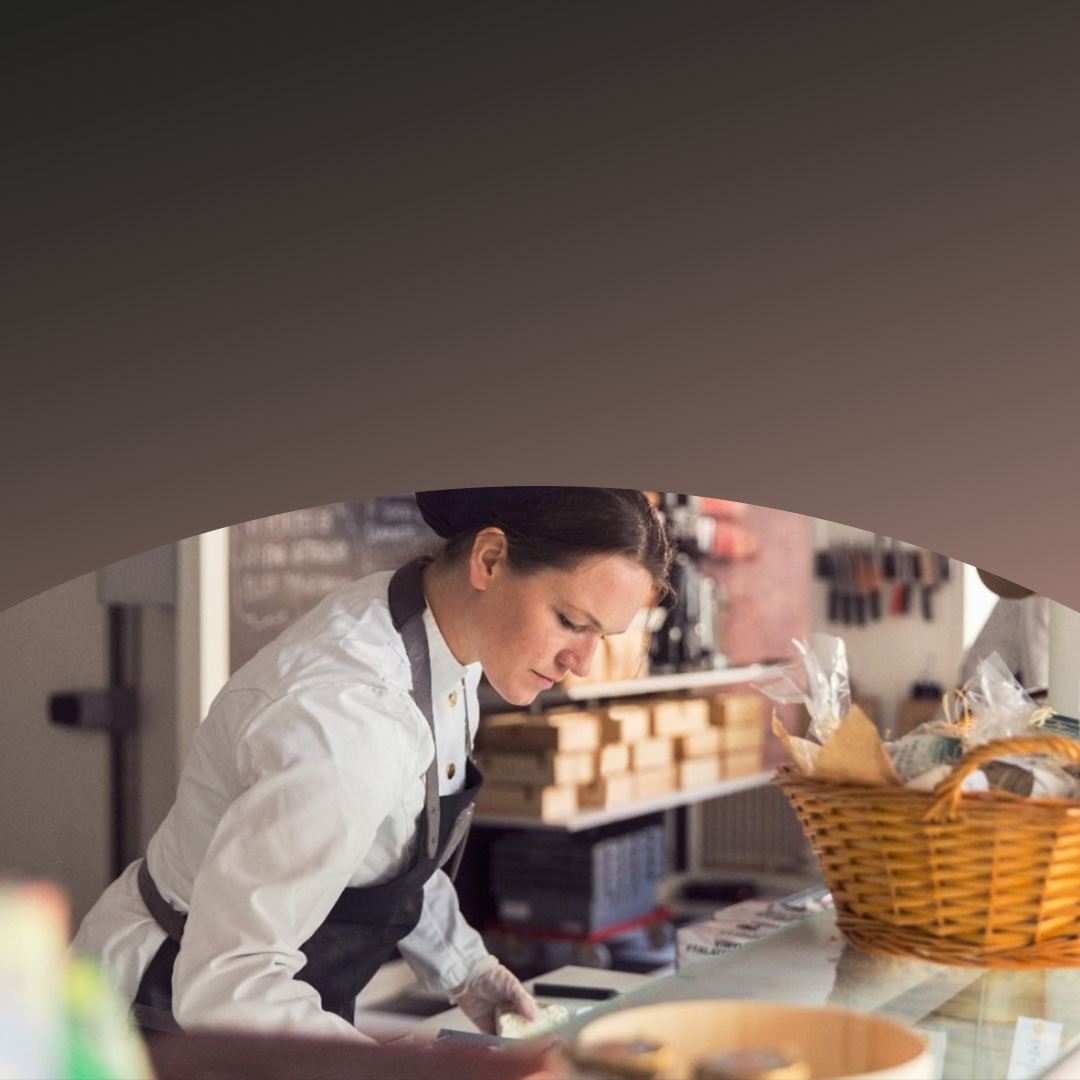 Ein Kleinunternehmer, umgeben von Versandkartons, der mit dem Telefon bezahlt. 