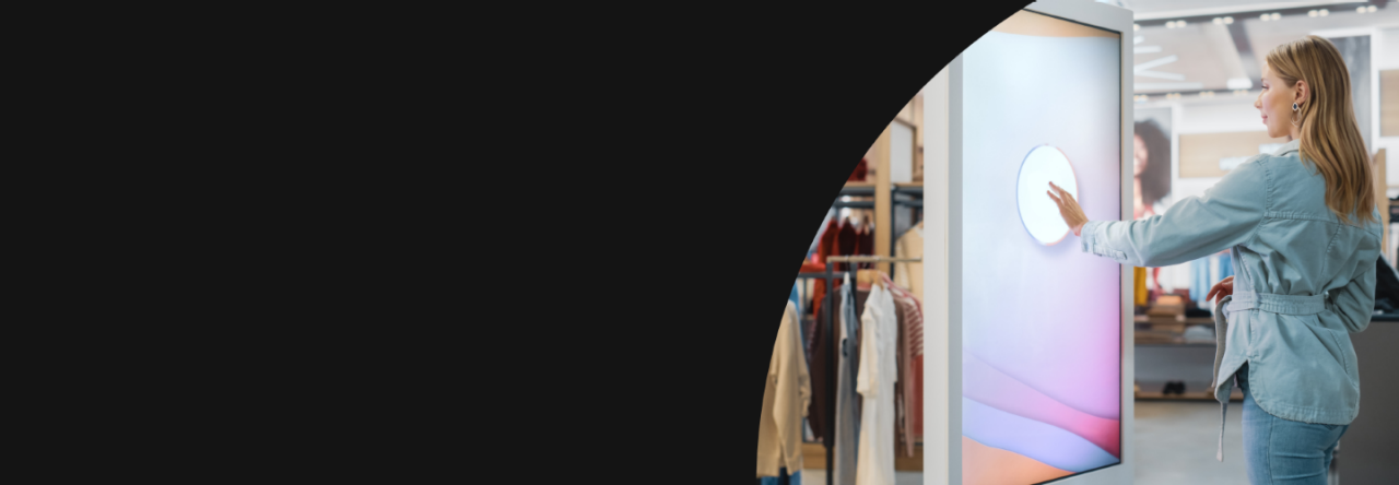 Frau benutzt einen grossen Touchscreen in einem Boutique-Bekleidungsgeschäft
