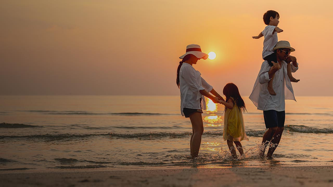 Familie am Strand bei Sonnenuntergang.