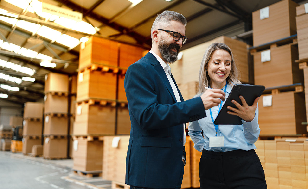 Une responsable d'entrepôt discute avec un employé de la logistique.
