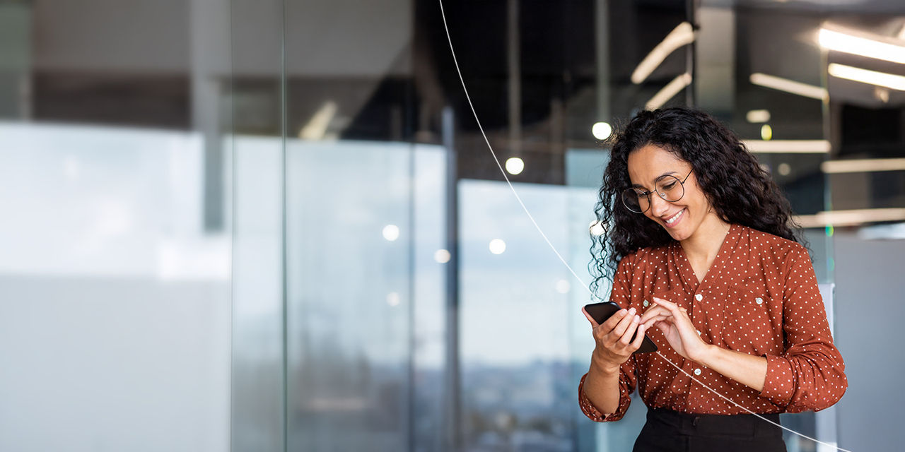 Femme d’affaires utilisant son téléphone sur le lieu de travail.