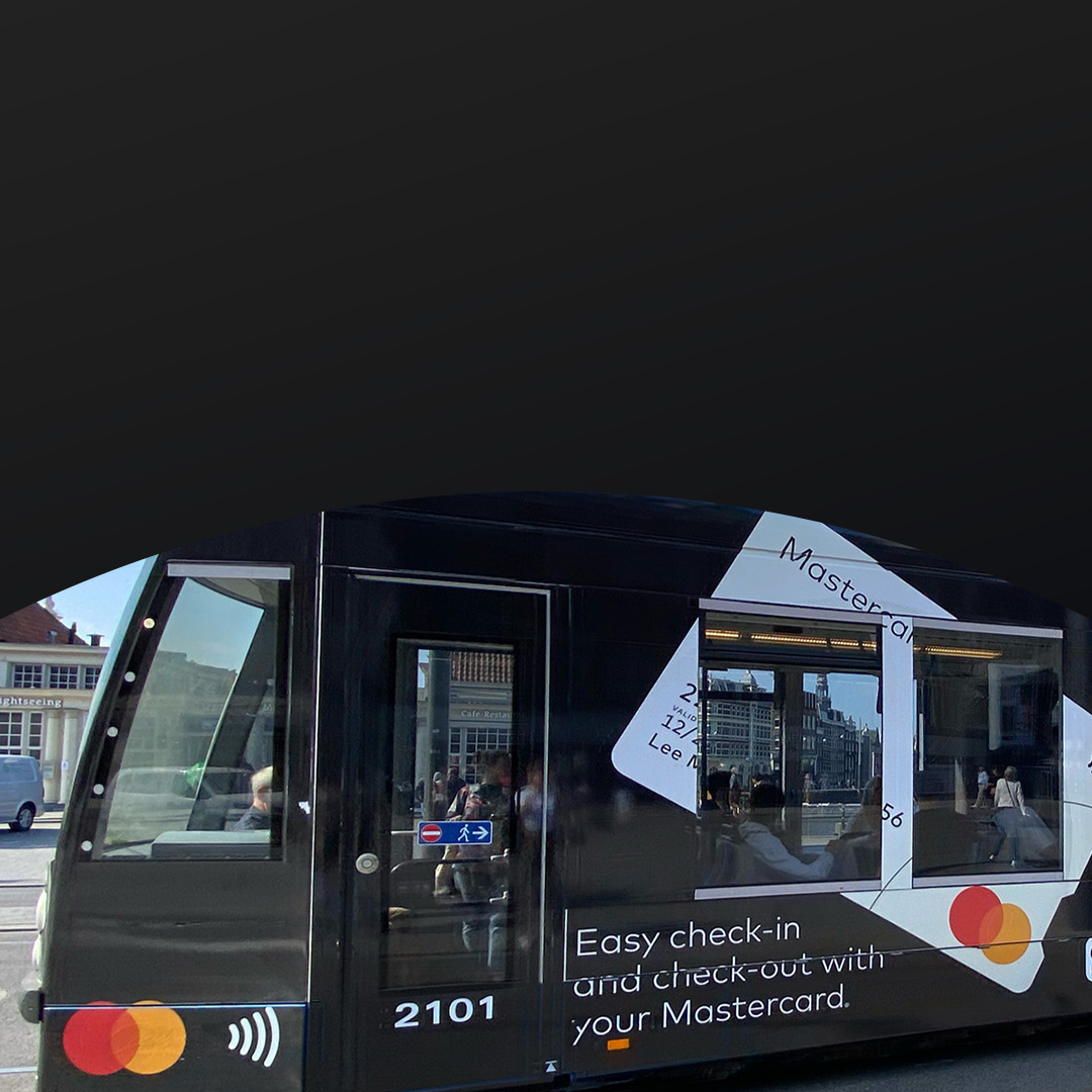 Un tramway noir avec une publicité Mastercard représente une carte de paiement sans contact, promouvant un enregistrement facile.