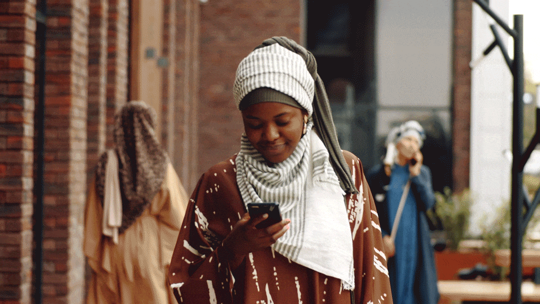 Femme marchant tout en regardant un smartphone.