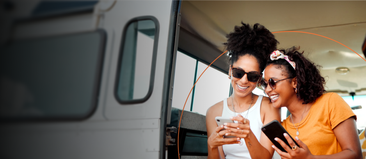 Two women in a van looking at their phone
