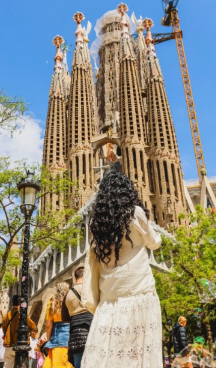 A woman takes a photo of La Sagrada Familia