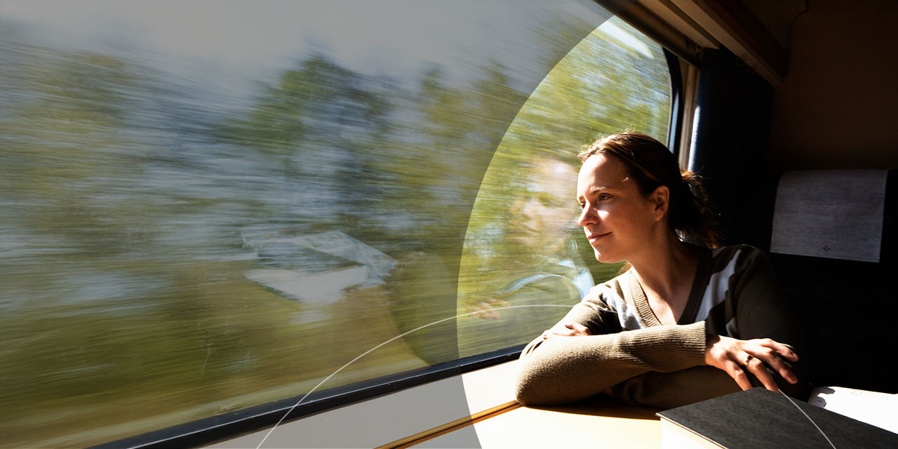 Mujer viajando en tren mirando por la ventana.