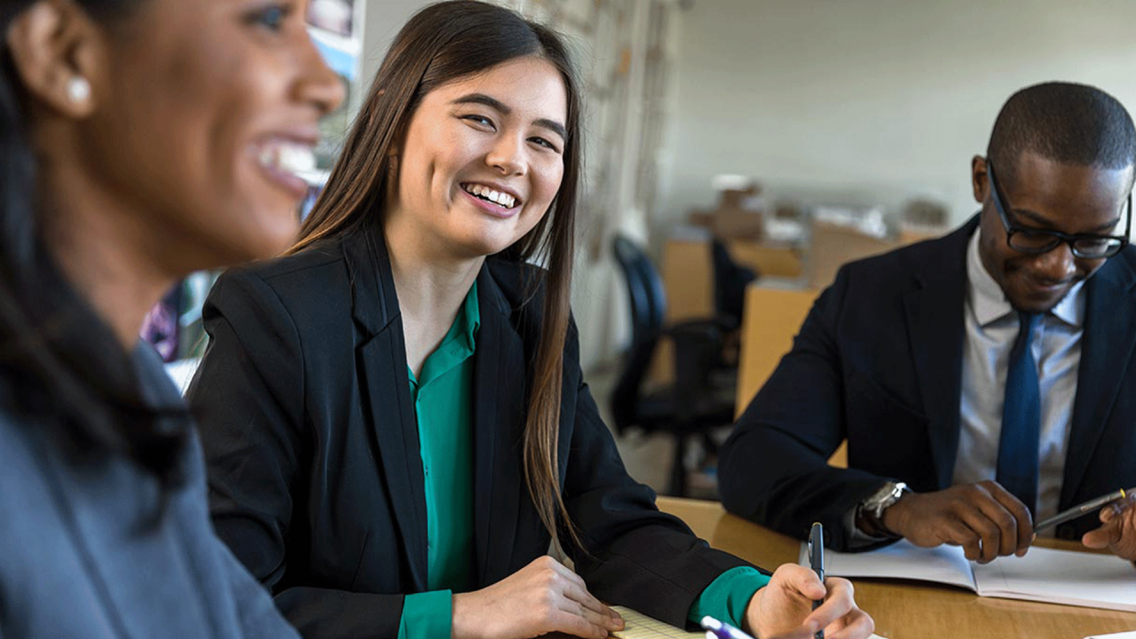 Mujer de negocios sonriente trabajando con sus colegas.