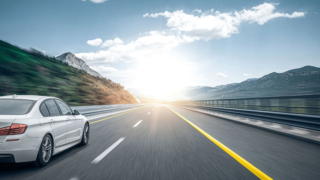 bílé auto na otevřené cestě