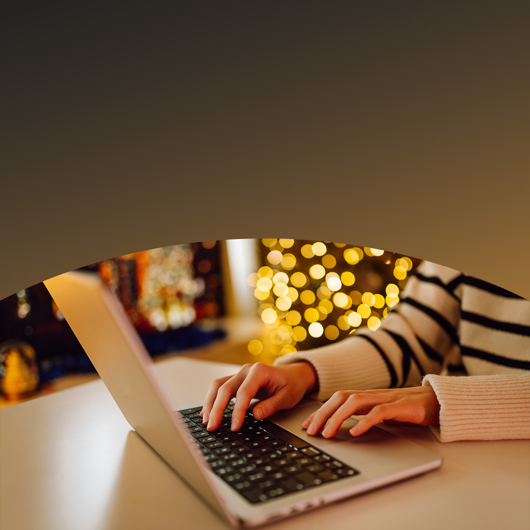 Eine Person tippt auf einem Laptop in einer gemütlichen Umgebung.