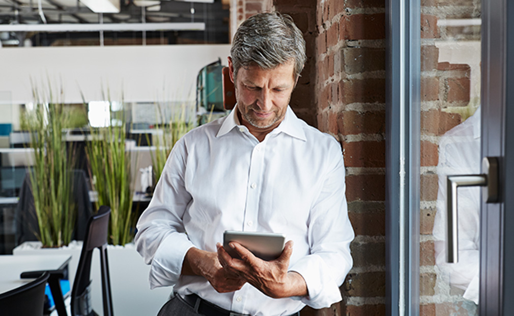 Mann benutzt sein Tablet im Büro