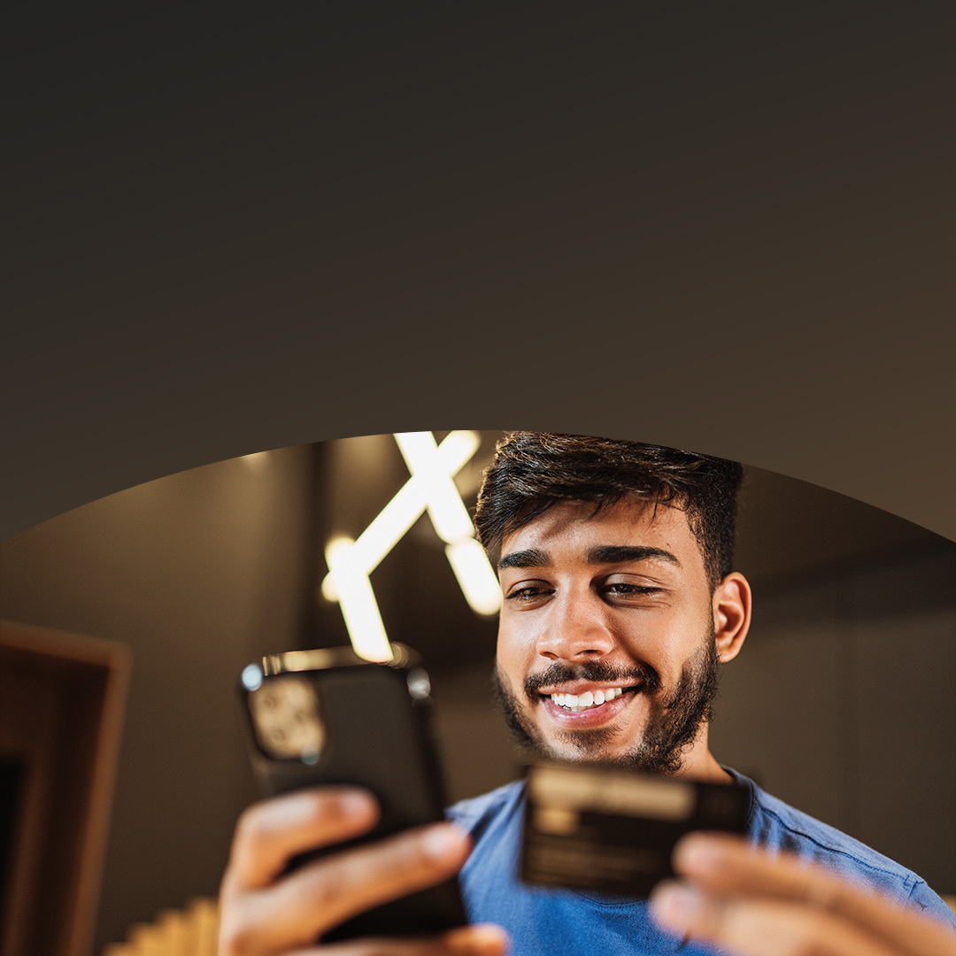 Ung mand med skæg, som handler online med sin mobiltelefon.