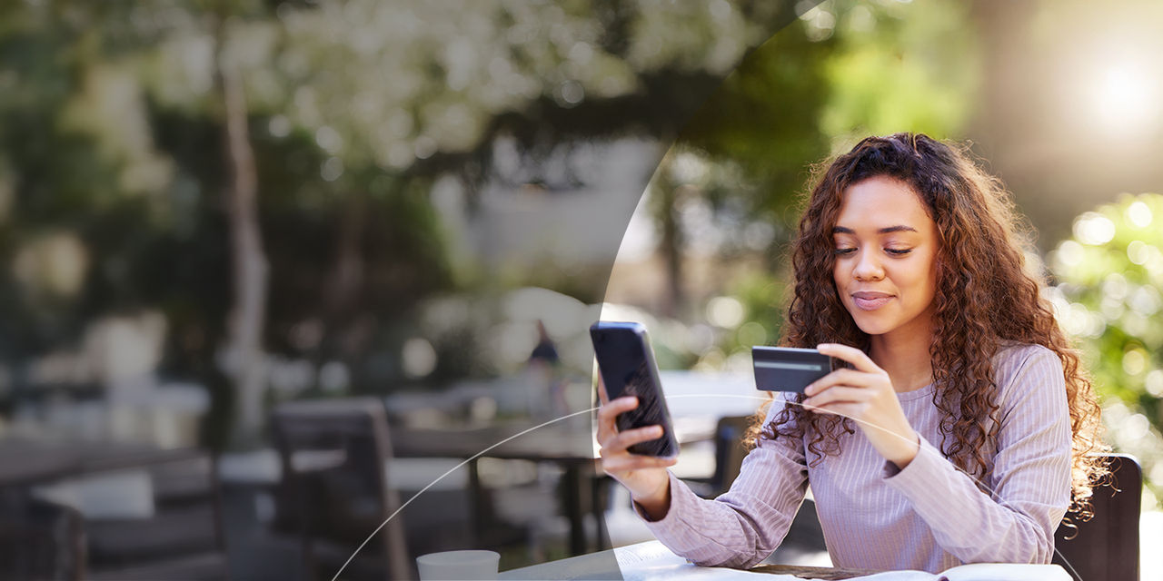 Kvinde betaler med kreditkort via sin smartphone på en restaurant.