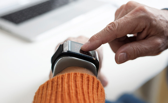 Una persona toca su reloj inteligente para revisar los detalles de la transacción.