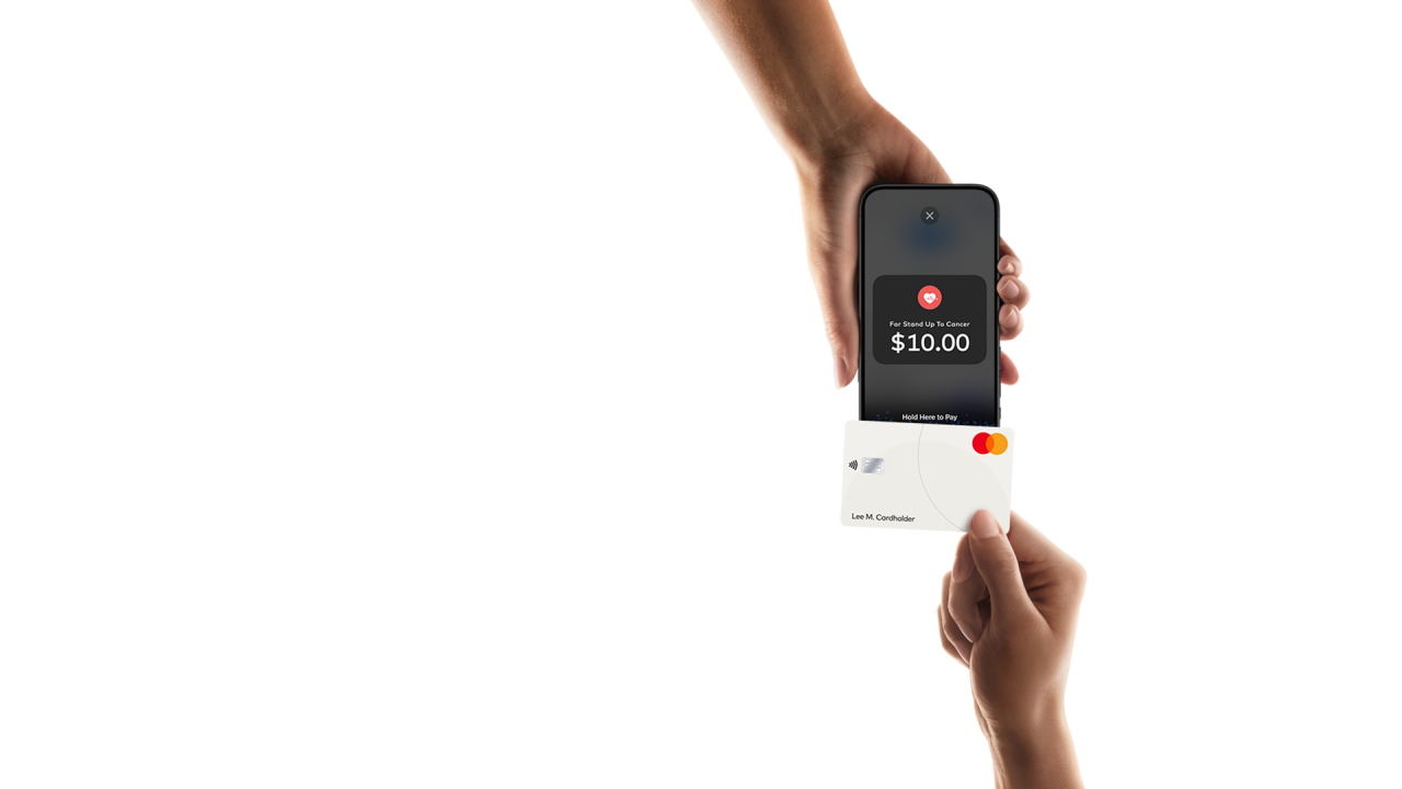 Tarjeta de crédito tocando un iPhone para pagar.