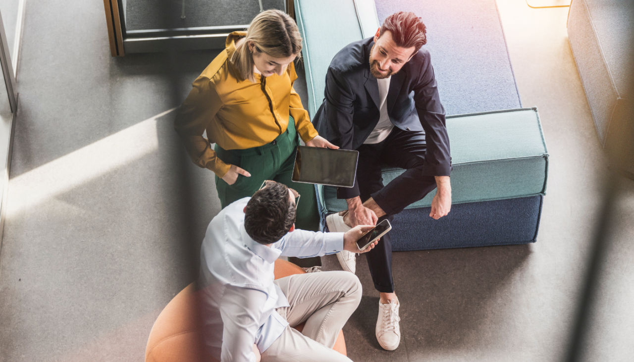 Three women brainstorming in front of a vision board