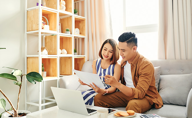 Portrait of beautiful young asian couple using laptop.