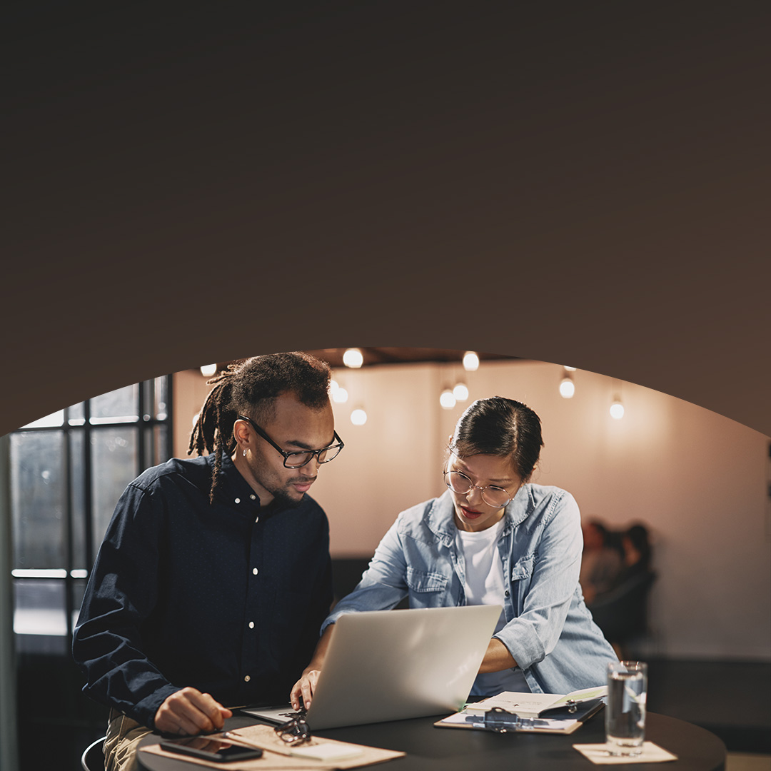 Two people reviewing data on laptop. 
