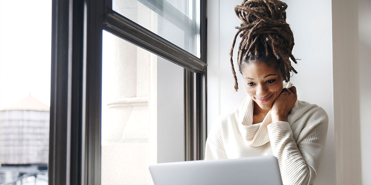 Woman using her laptop by the window