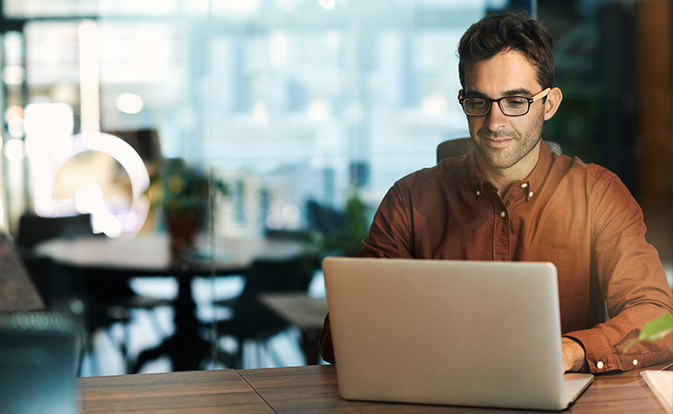 A man working on his laptop at a table.