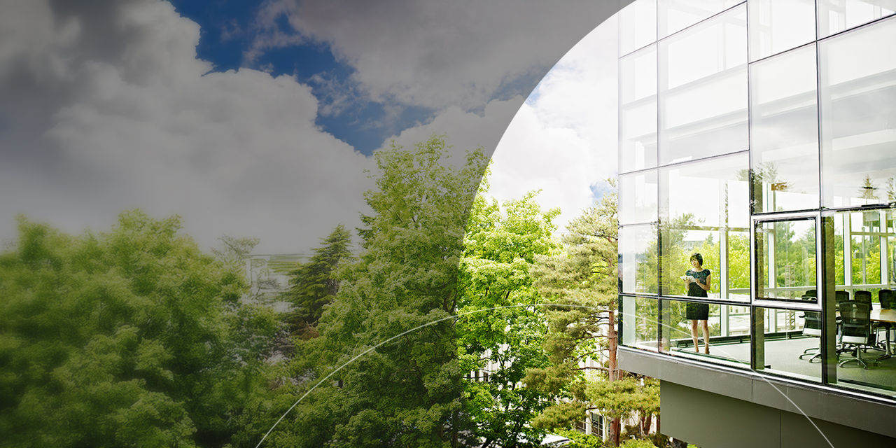 Woman standing inside glass office building.