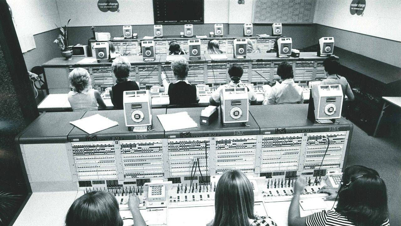 Rows of employees at switchboards that help authorization of credit cards. 