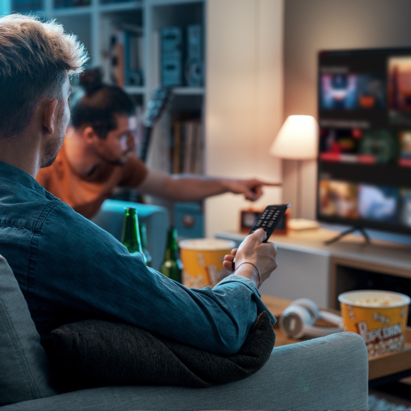 A group of friends watch TV together.