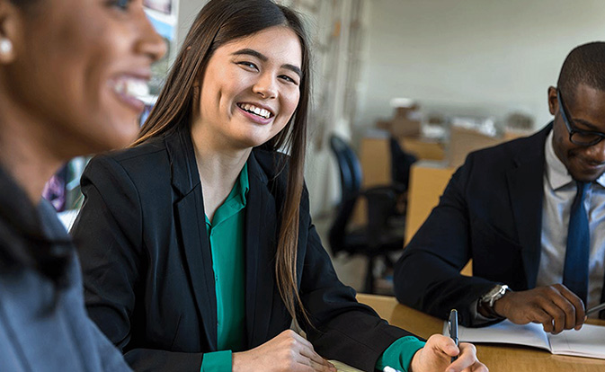 Une femme d’affaires souriante travaillant avec ses collègues.