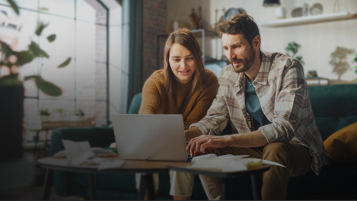 Woman and man sitting on couch doing accounting at home.
