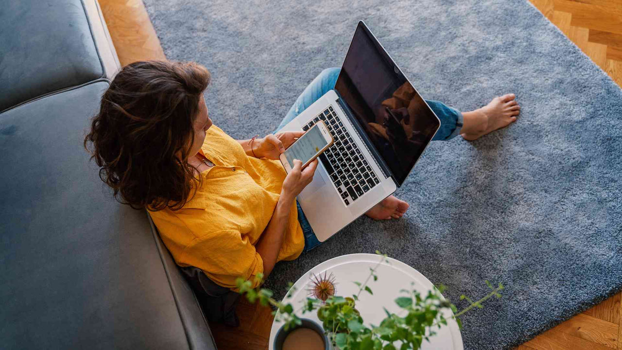 A woman sitting on the floor using a laptop