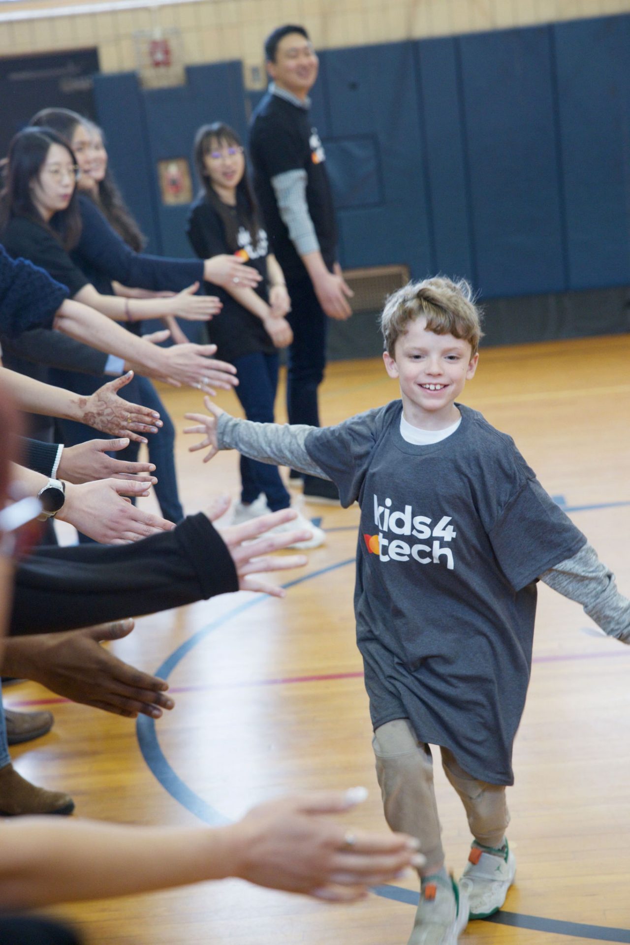 Young boy giving row of people high fives.