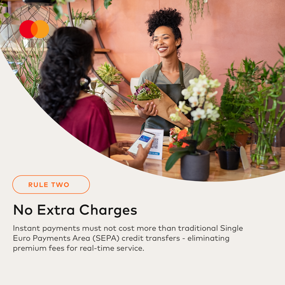 A smiling florist hands a bouquet to a customer holding a phone for payment.