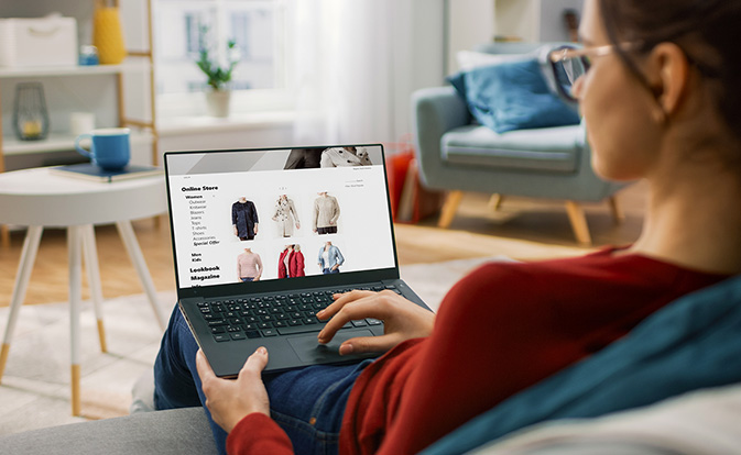 Woman in red jumper shopping online.