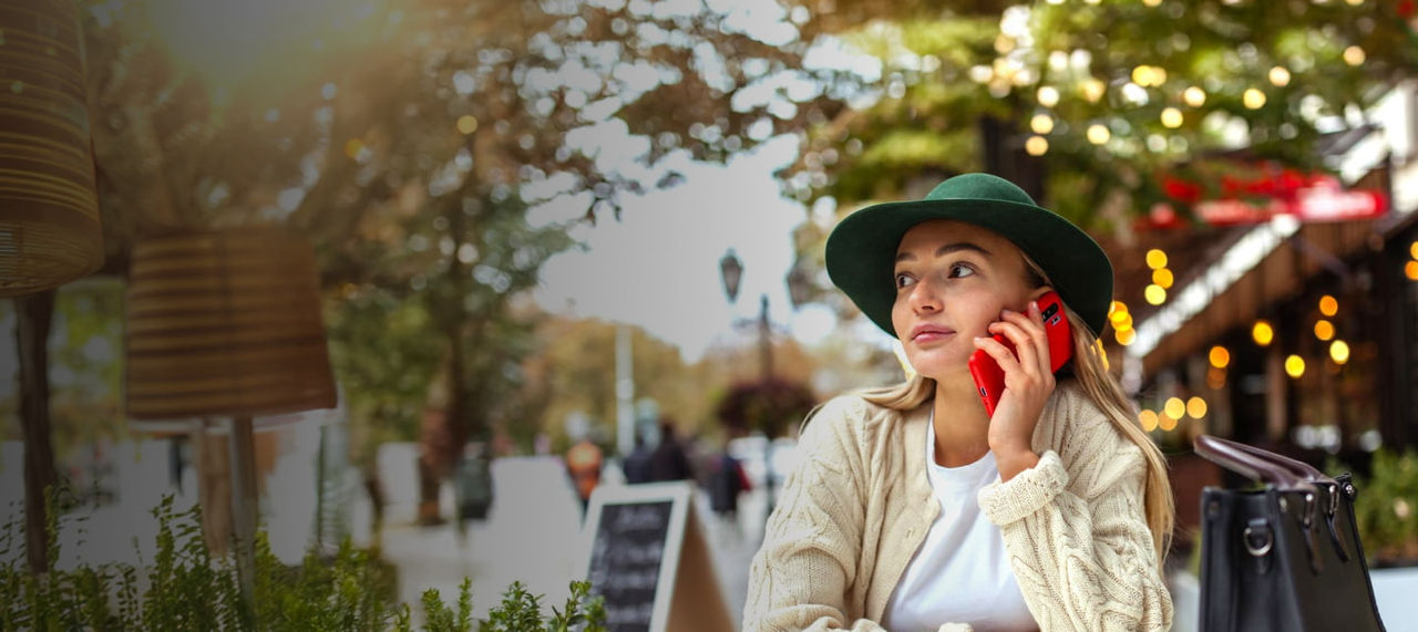 woman wearing hat on a phone