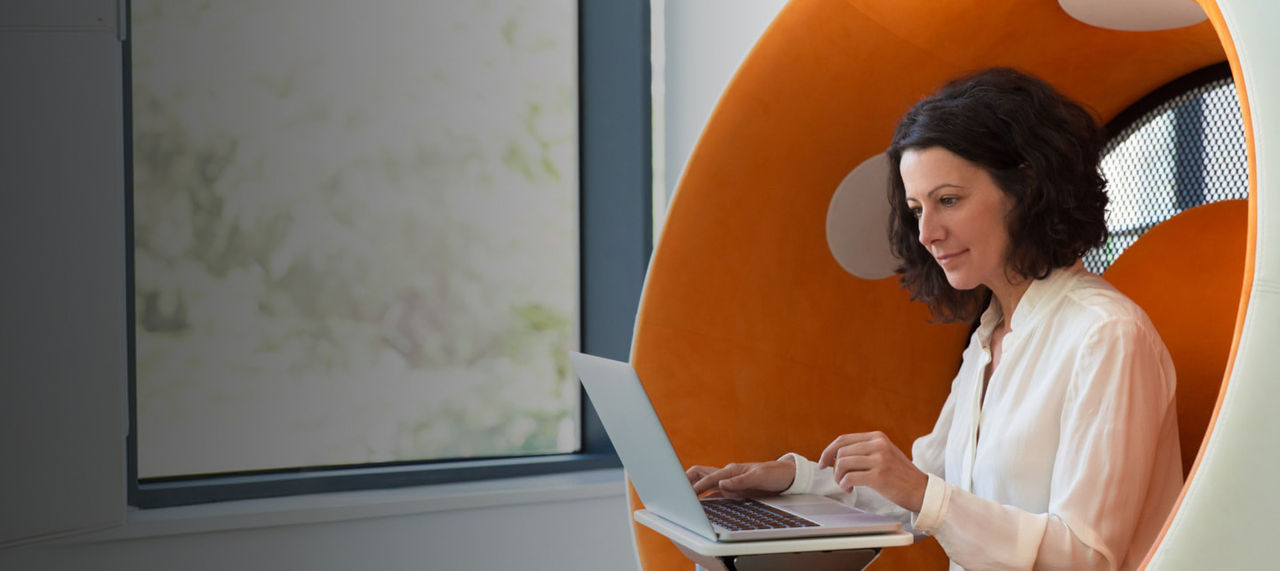 woman sitting inside an orange pod