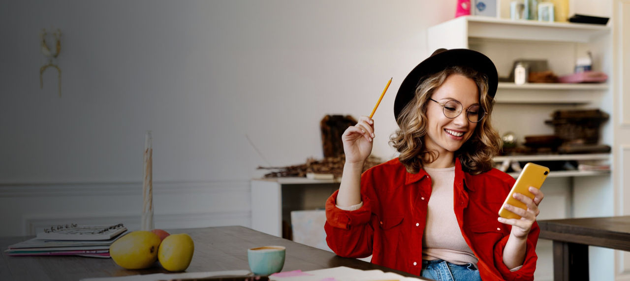 woman wearing hat holding phone