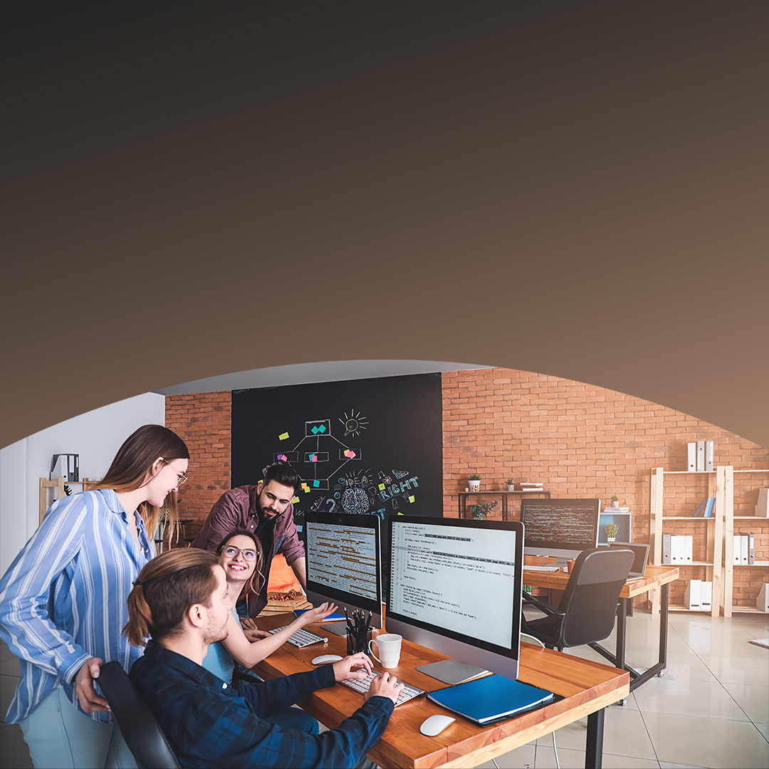 Mitarbeiter, die gemeinsam an einem Schreibtisch und Computer arbeiten. 