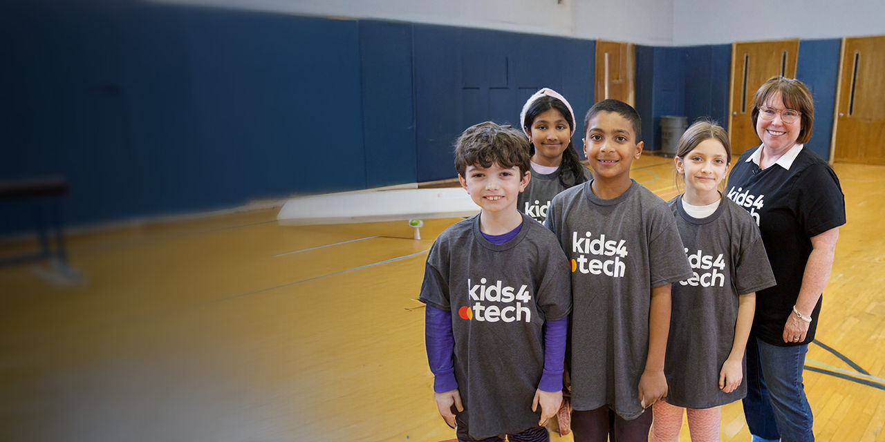 Four kids and their teacher wearing kids 4 tech t-shirts