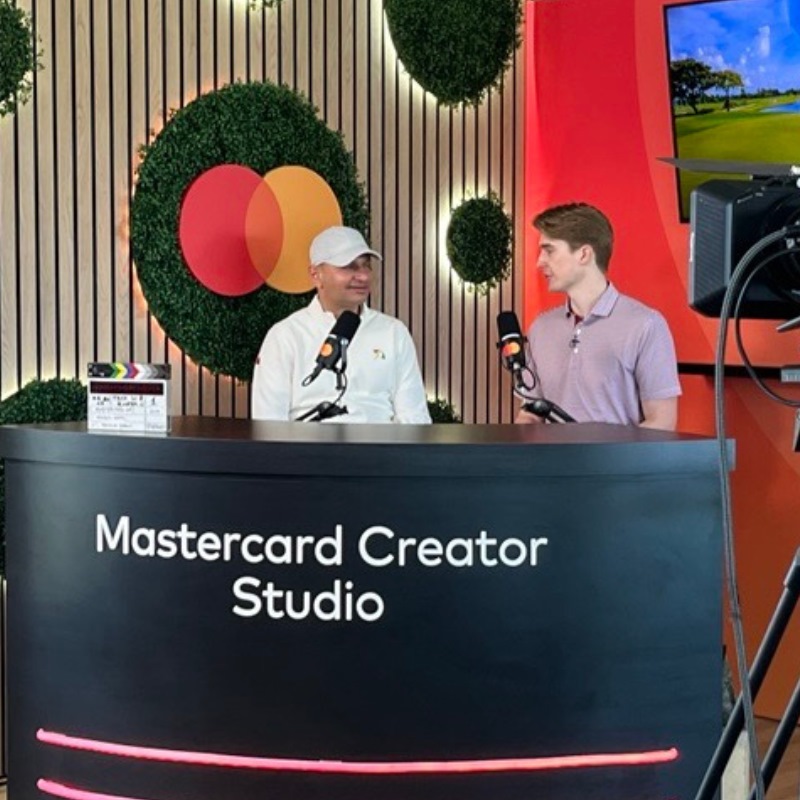 A Mastercard-branded McLaren car on stage with smoke rising behind it. 