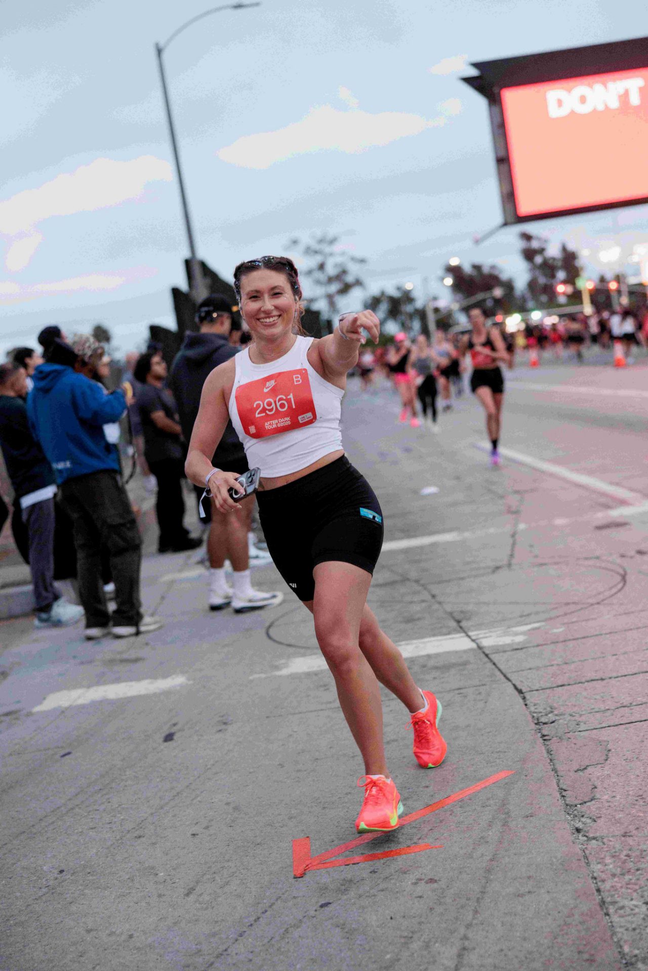 Mallory Kilmer points to the camera during a marathon