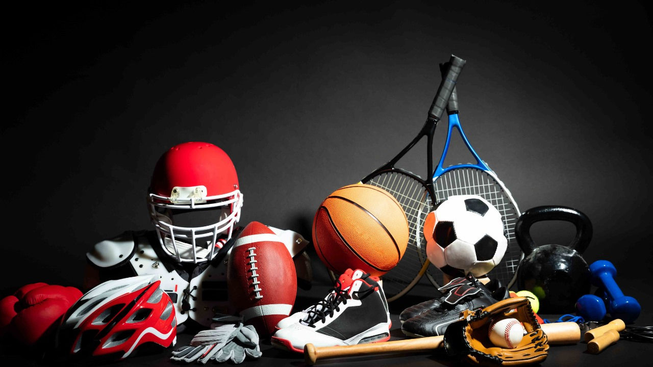 Sports equipment, including a soccer ball, football, football helmet, tennis rackets, baseball, bike helmet and basketball and bat. 